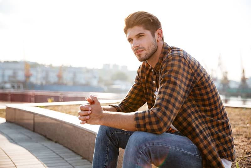 jove guapo assegut en profunds pensaments