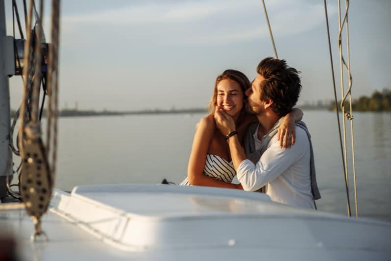 pasangan romantis di atas kapal menikmati hari pria mencium wanita