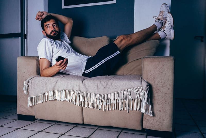 Mann liegt auf dem Sofa