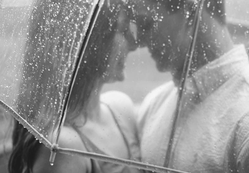 Glückliches Paar unter einem Regenschirm im Regen