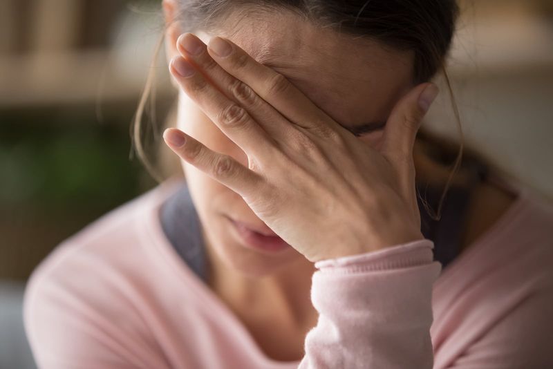 dona preocupada agafant la mà al front