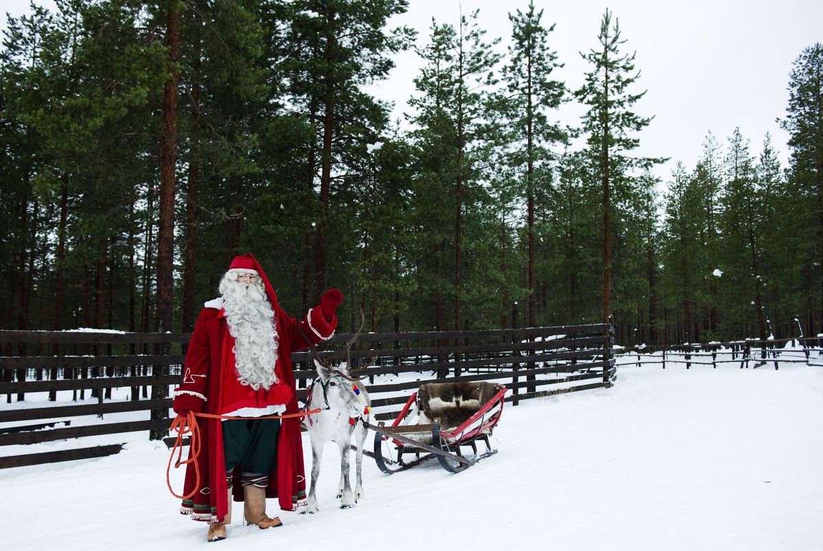 El Pare Noel fa una onada mentre està dret amb una re