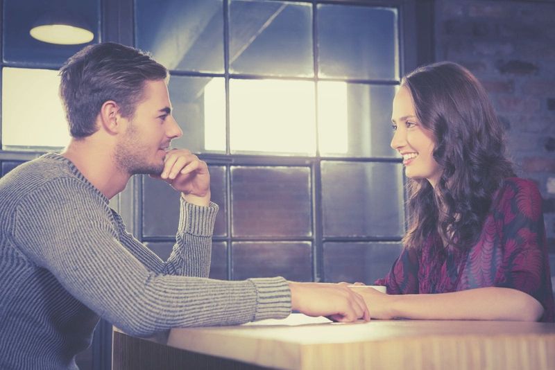 casal de namorados conversando e sorrindo em um restaurante