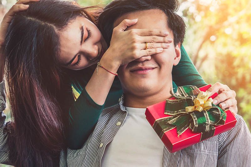 Frau überrascht Freund mit Weihnachtsgeschenk