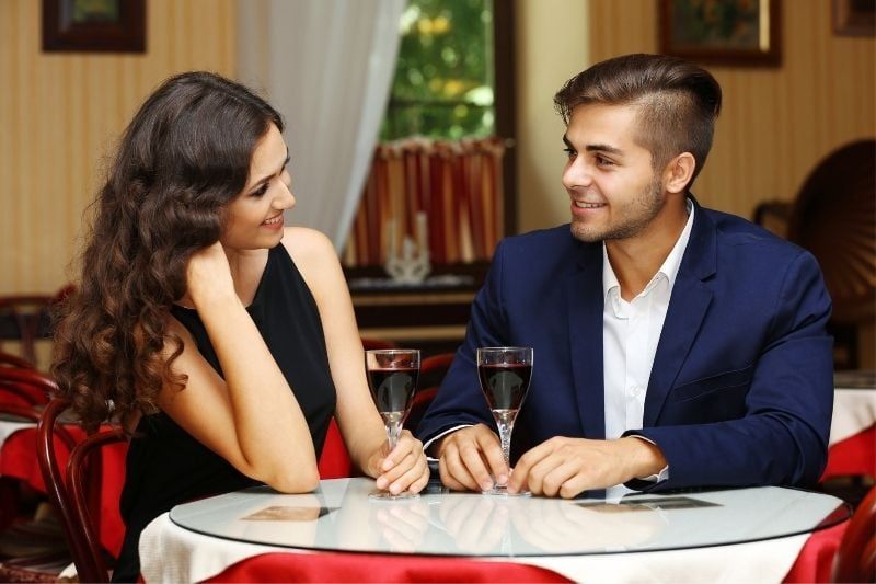 cuplu care ia cina într-un restaurant purtând haine casual