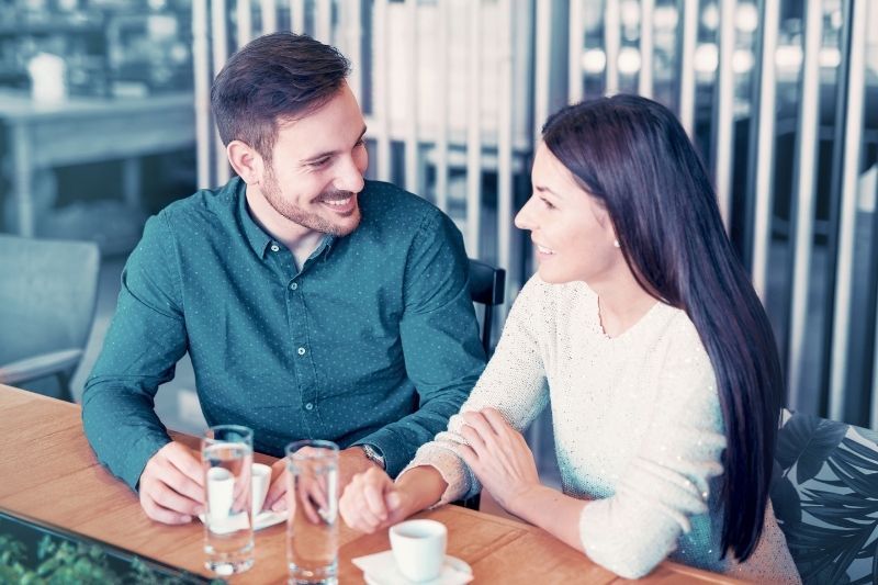 bărbat zâmbitor la cafea într-o cafenea în aer liber