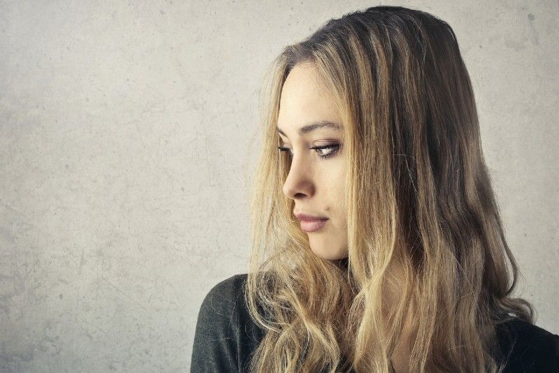 blonde frau, die nahe wand steht
