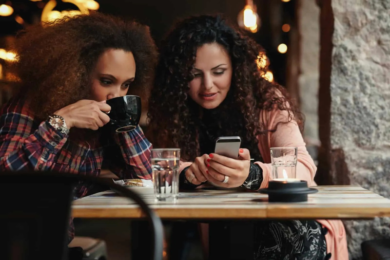   Zwei Freunde sitzen an einem Tisch und unterhalten sich bei einem Kaffee
