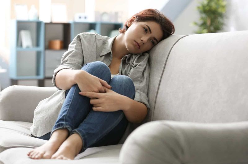 triste mulher sentada no sofá