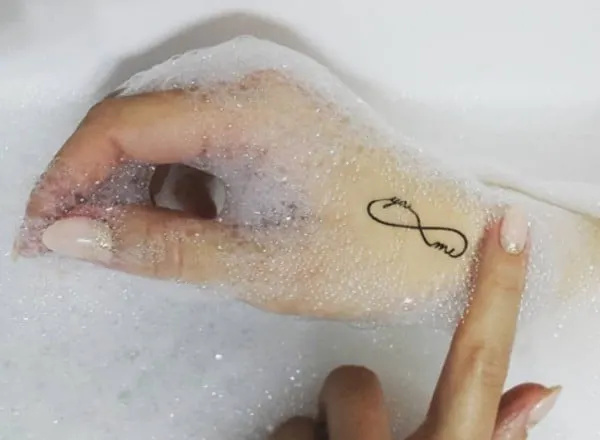   Татуировка със символ на'infinito "You and me inside" sulla mano