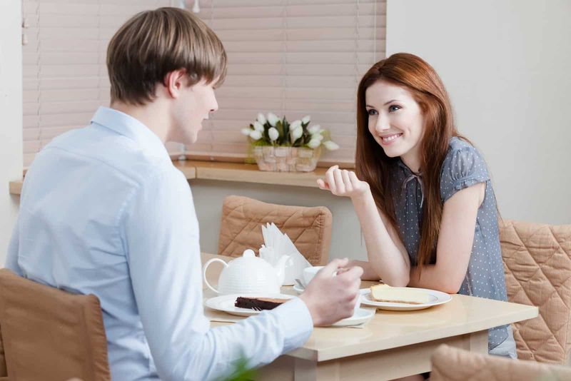 un bărbat și o femeie zâmbitori care vorbesc la o cafea