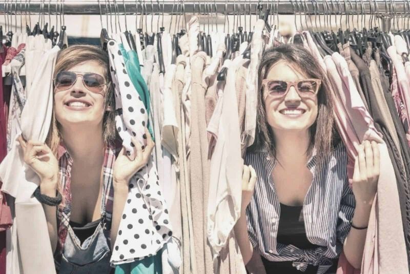dwie kobiety, które bawią się powieszonymi sukienkami