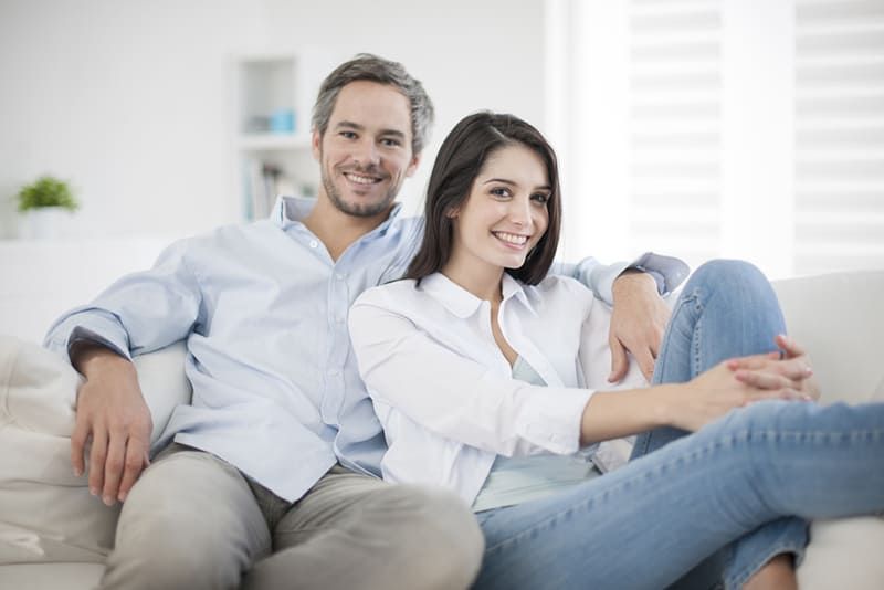 ngồi ở nhà một cặp vợ chồng đang mỉm cười