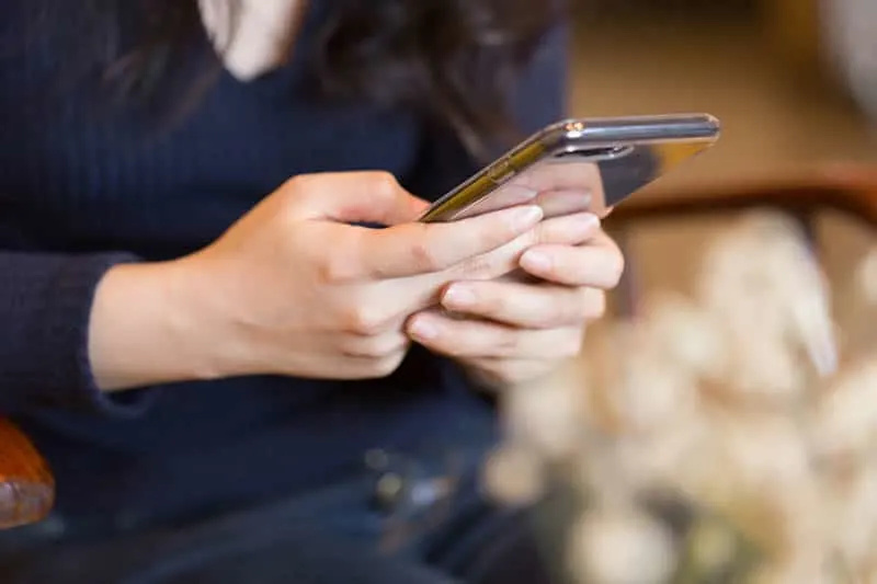 nærbilde av en kvinne som sender tekstmeldinger på mobiltelefonen hennes