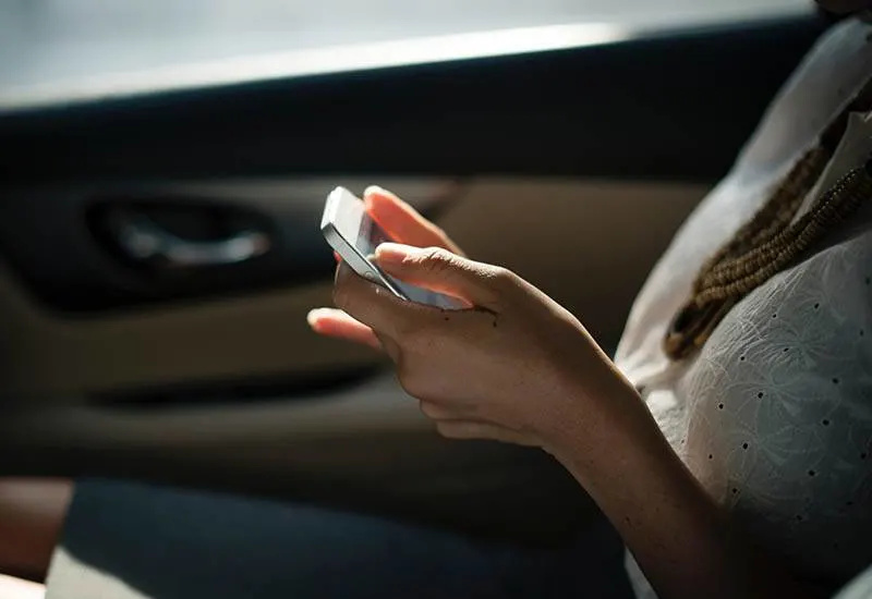 nærbilde av en kvinne som skriver på telefonen i bilen