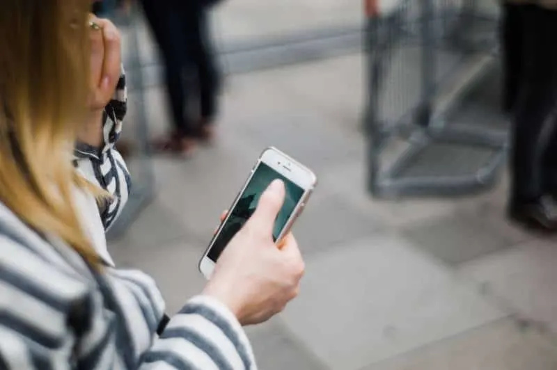 jente skriver på en telefon utendørs'esterno