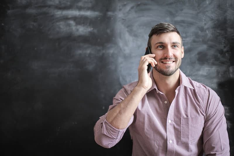 homem feliz falando ao telefone