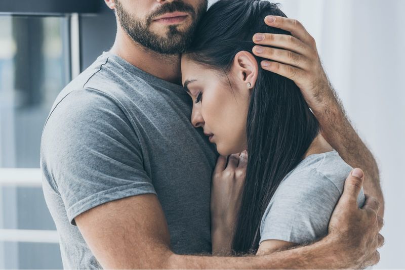 pria memeluk wanita sambil berdiri di dalam ruangan