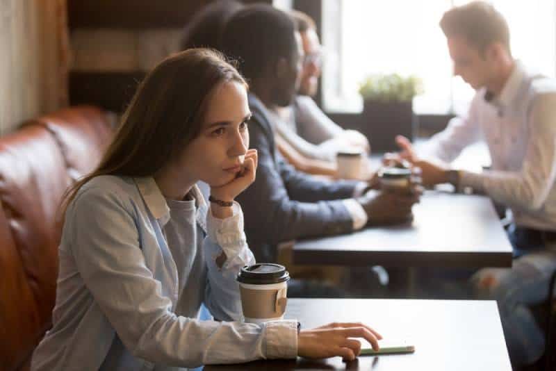 cô gái buồn bã ngồi ở quán cà phê
