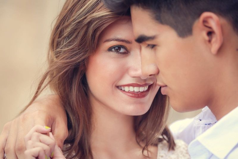 منظر جانبي لرجل يعانق امرأة في مواجهة الكاميرا مع تركيز رأسه