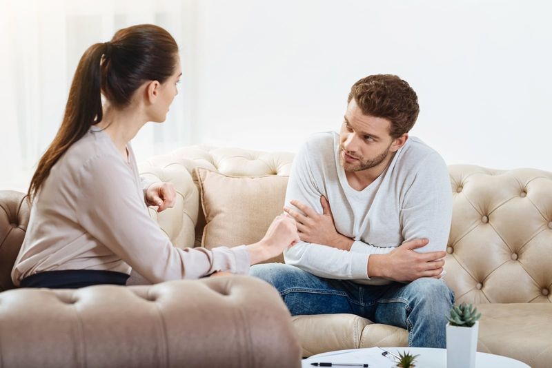 man en vrouw praten terwijl ze op de bank zitten