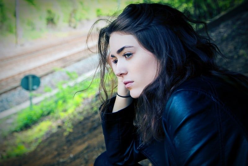 vrouw in zwarte jas die overdag buiten zit