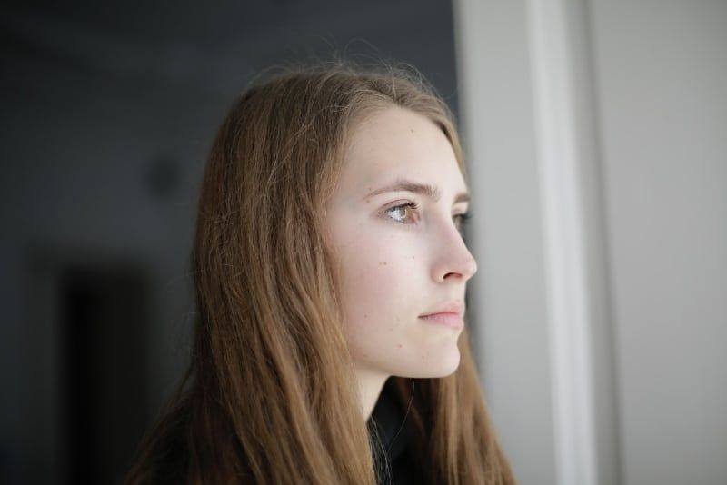 peinzende vrouw die in de woonkamer staat