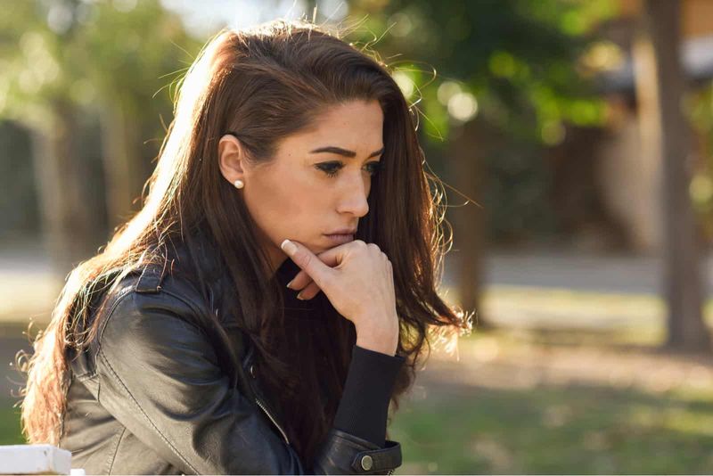 Doordachte vrouw zitten in het park