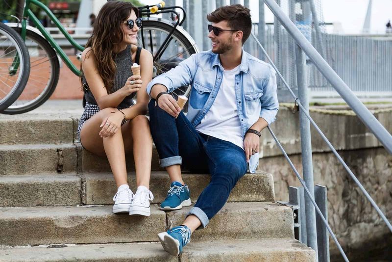 người đàn ông và phụ nữ ăn kem khi ngồi trên cầu thang