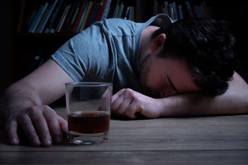 alkoholsüchtiger mann schlief ein, während er bier im glas trank