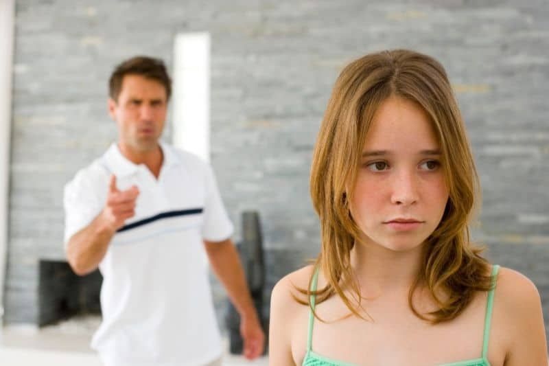 kritischer vater, der seine tochter zu hause tadelt