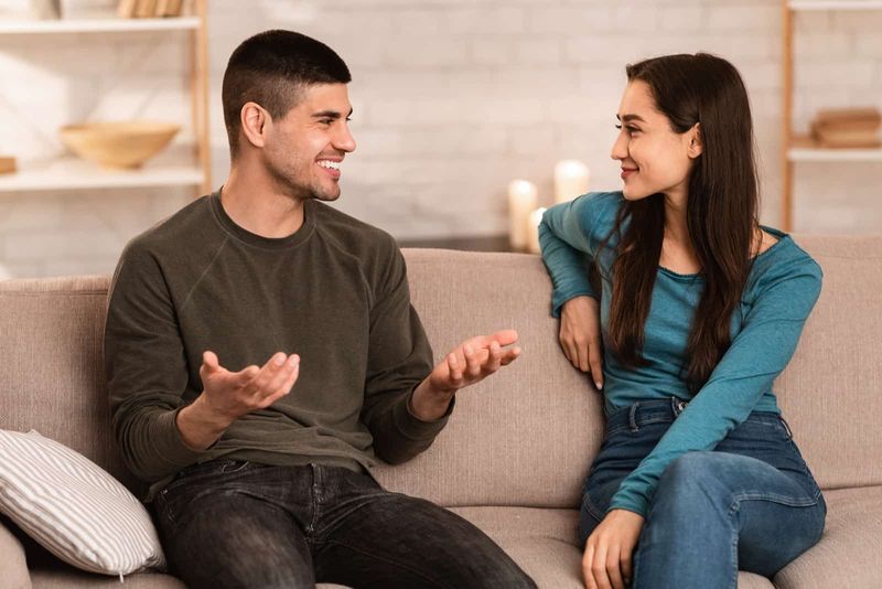 الرجل الذي يتحدث إلى المرأة أثناء جلوسها على الأريكة