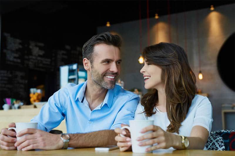 lächelnder mann und frau sitzen im café