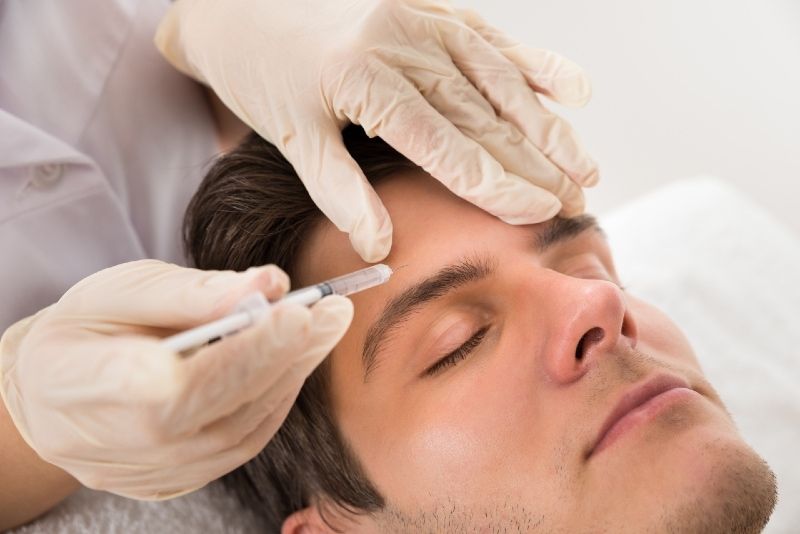 رجل مغلق العينين يخضع للعلاج بالبوتوكس