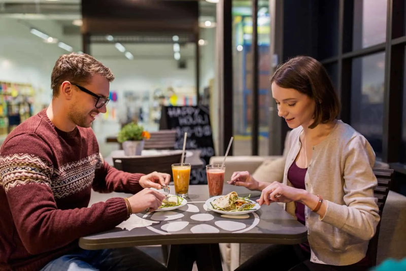   Ein schönes Paar sitzt in einem Restaurant und unterhält sich beim Essen