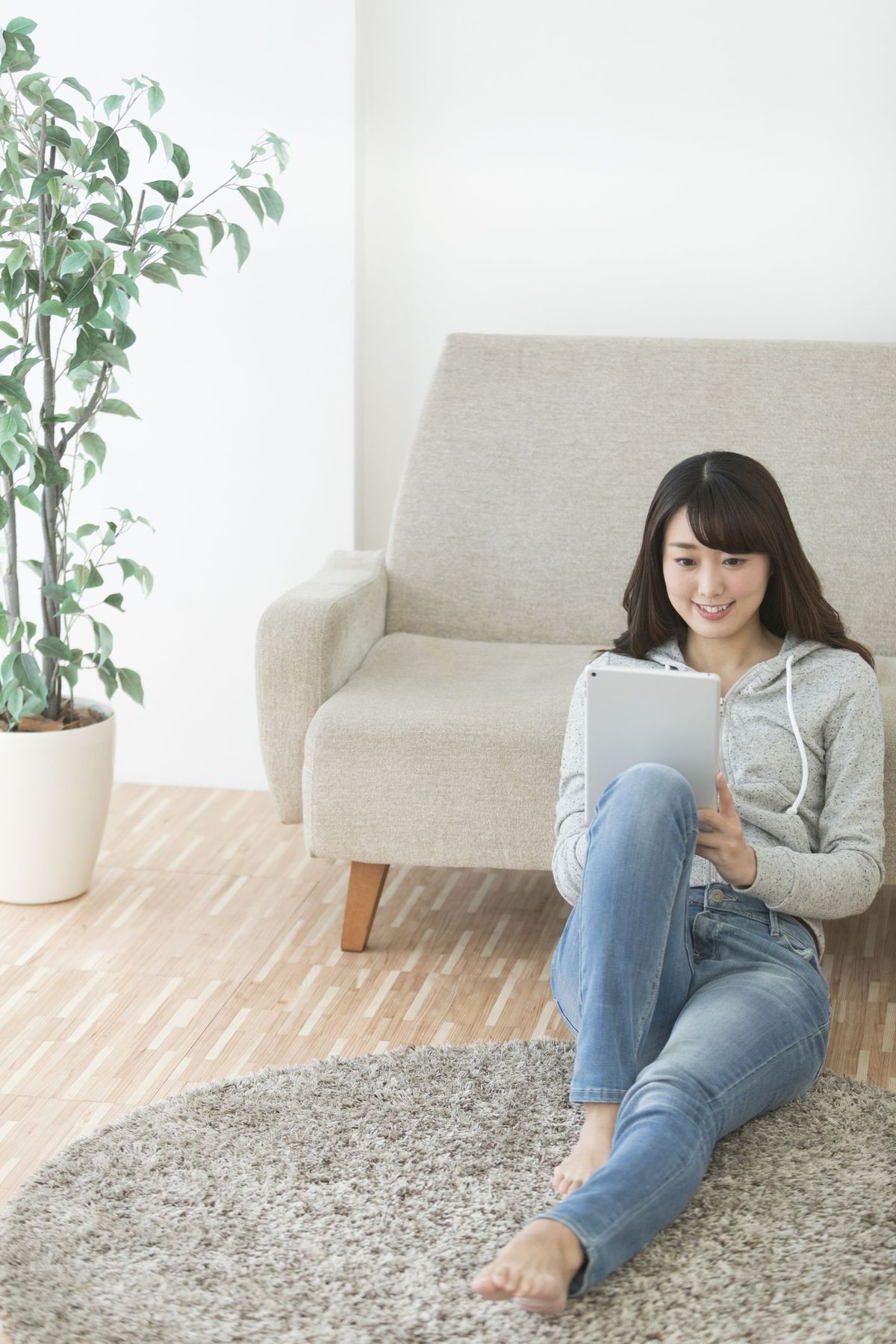 người phụ nữ mỉm cười nhìn máy tính bảng
