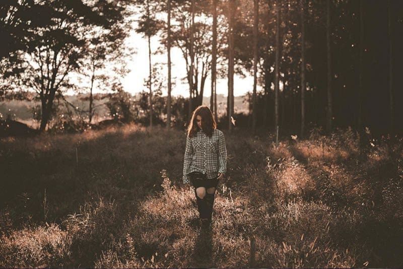 mulher pensativa andando na natureza