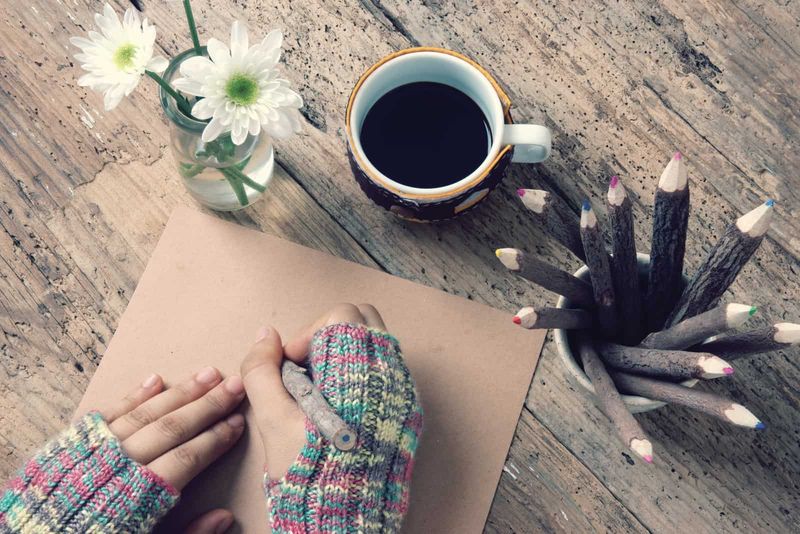 Vrouwen dragen in de winter wollen handschoenen en schrijven een brief voor hem