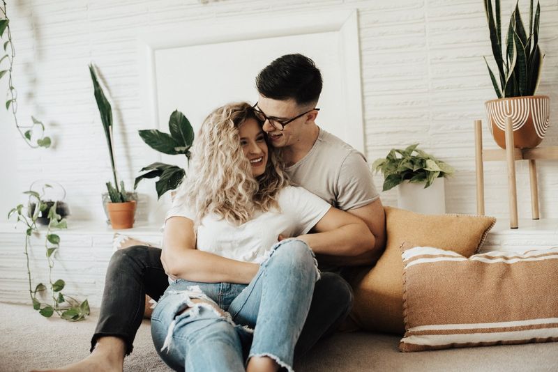 người đàn ông và phụ nữ ngồi trên sàn nhà gần cây
