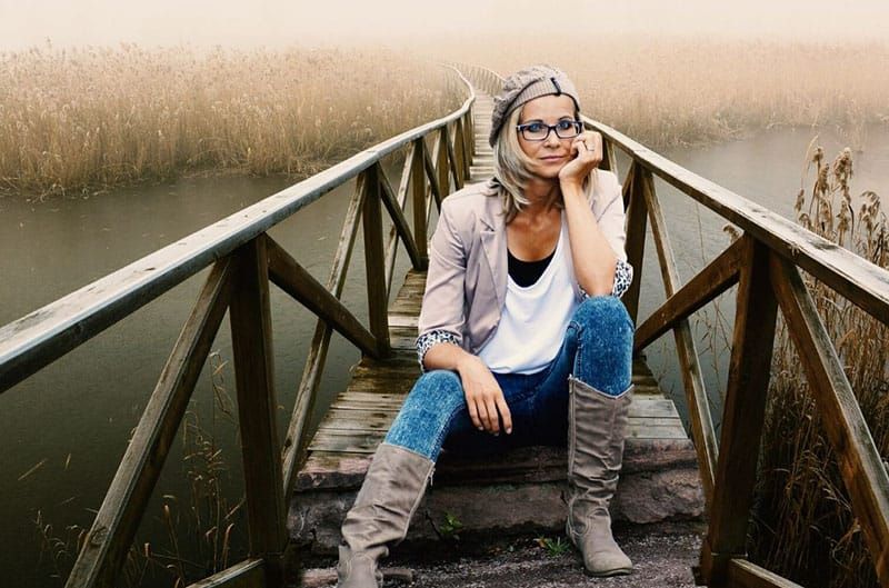 dona asseguda en un pont en ruïnes sobre una massa d
