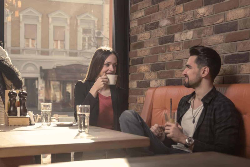 un bărbat și o femeie stau într-o cafenea și vorbesc