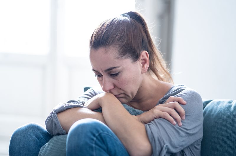 femeie deprimată care stă pe podea gândindu-se cât de complicată este dragostea