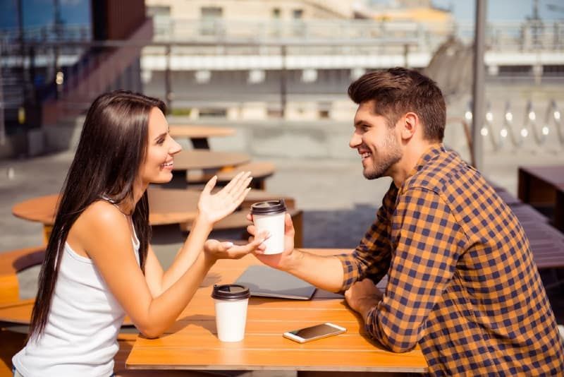 femeie și bărbat zâmbitori la cafea în aer liber