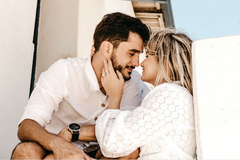 άνδρας και γυναίκα έτοιμοι να φιληθούν ενώ κάθονται σε εξωτερικούς χώρους