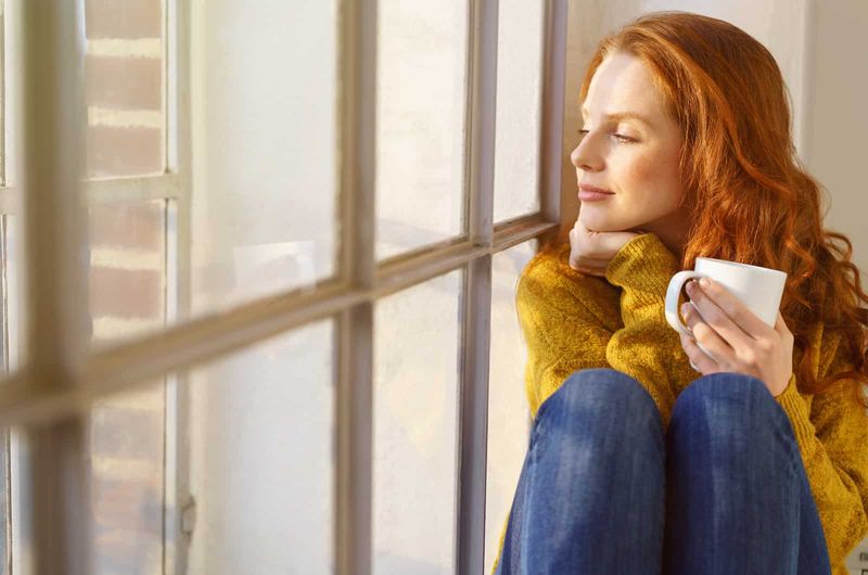 mujer mirando por la ventana