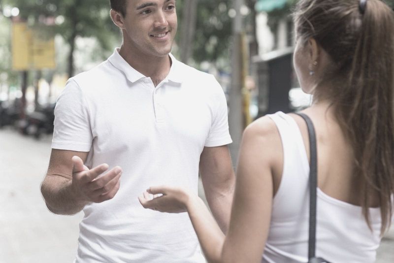 homem e mulher com tops brancos conversando na rua