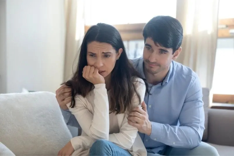 צעיר אשם אומר סליחה לאישה לחוצה נסערת בתוך הסלון