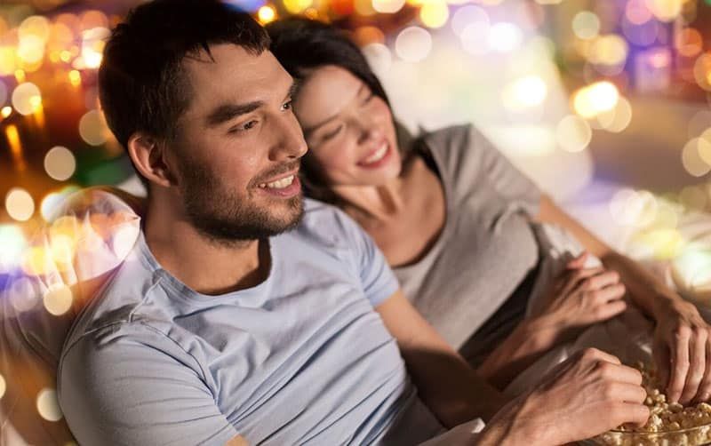 pasangan kencan malam tv dengan wanita bersandar pada pria dengan lampu di sekitar