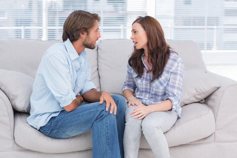 nag-uusap ang lalaki at babae habang nakaupo sa sofa
