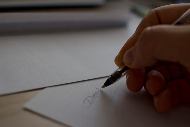 رجل يكتب رسالة من خلال الورقة البيضاء